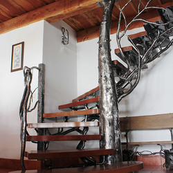 Kunstvolle Treppe mit Gelnder in Form eines Baumes, hergestellt aus natrlichen Werk-stoffen, Metall und Holz  modernes Gelnder