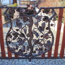 Toranlage  Wappen mit Weinrebe  handgeschmiedetes, mit Holz kombiniertes Tor an einem Einfamilienhaus