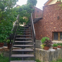 Exterior staircase with railing as aloft apartment entrance