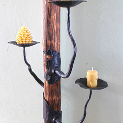 Schmiedeeiserner Kerzenhalter an einem Holzstnder