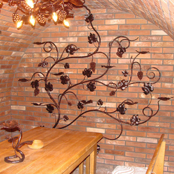 Kerzenleuchter, geschmiedete Weinrebe an der Wand  kunstvoller Kerzenleuchter in einem Weinkeller
