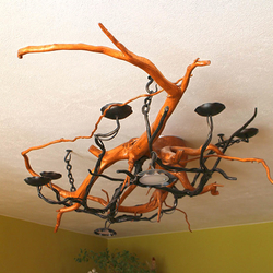 Plafonnier de style rustique, la pièce forge en forme de chandelier de campagne marie à la branche darbre