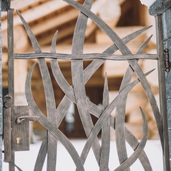 Geschmiedete Pforte mit Grasmuster als Teil der außergewöhnlichen Umzäunung der Hütte – künstlerische Tore und Zäune Geschmiedete Pforte mit Grasmuster als Teil der außergewöhnlichen Umzäunung der Hütte – künstlerische Tore und Zäune