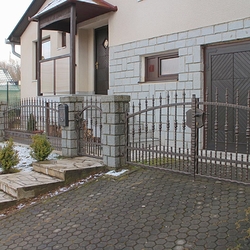 Schmiedeeiserne Umzäunung eines Einfamilienhauses – geschmiedeter Zaun mit verdichteten Elementen im unteren Teil Schmiedeeiserne Umzäunung eines Einfamilienhauses – geschmiedeter Zaun mit verdichteten Elementen im unteren Teil