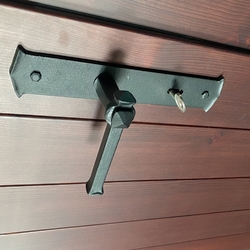 Kované kliky a štítky na dveřích pokojů rodinného domu