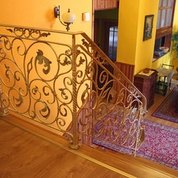 A wrought iron white railing with gold-green patina A wrought iron white railing with gold-green patina