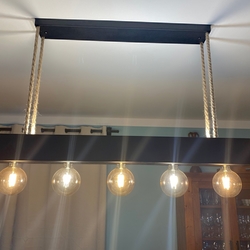 Designový kovaný lustr zavěšený na lanech - moderní svítidlo nad jídelním stolem