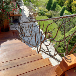 Designgeländer für die Treppe im Exterieur einer Familienhütte – außergewöhnliches geschmiedetes Geländer mit höher Qualität 