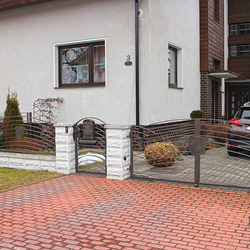 Modernes Design mit Buchstabenwappen – geschmiedetes Tor und Zaun an einem Einfamilienhaus Modernes Design mit Buchstabenwappen – geschmiedetes Tor und Zaun an einem Einfamilienhaus