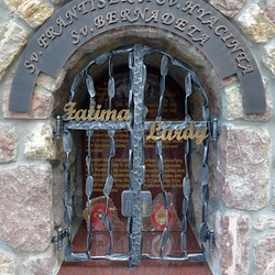 Kovaný památník - nápis, mříže a poznávací znak. Sv. František a Sv. Hyacinta - nápis Fatima, Sv. Bernadeta - nápis Lurdy