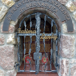 Kovaný pamätník - nápis, mreže a poznávací znak. Sv. František a Sv. Hyacinta - nápis Fatima, Sv. Bernadeta - nápis Lurdy Kovaný pamätník - nápis, mreže a poznávací znak. Sv. František a Sv. Hyacinta - nápis Fatima, Sv. Bernadeta - nápis Lurdy