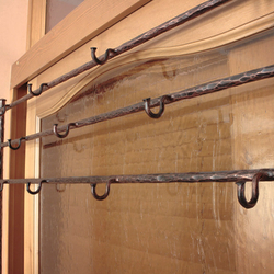 Kovaná věšáková stěna s botníkem - detail věšáků - originální nábytek do předsíně