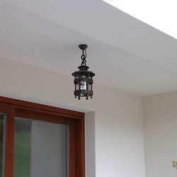 A wrought-iron hanging light HISTORICAL in the exterior of a family house - luxury lights