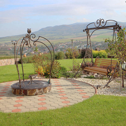 A wrought iron rocking bench and a wrought iron dome for a well