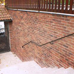 Kovaná branka s plechem a kované madlo na exteriérovém schodišti
