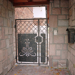 Ručně kovaná branka s plechem a kovaná schránka při vstupu do rodinného domu