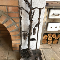 Hand-forged fireplace tools PINE by the outdoor fireplace in a summer house