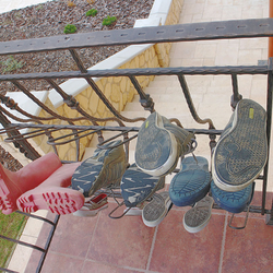 Kované zábradlí při vstupu do domu s kovaným stojanem na boty