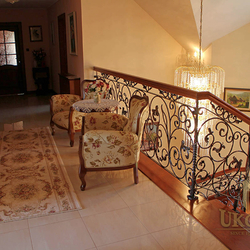 A wrought iron railing with a wooden handrail A wrought iron railing with a wooden handrail