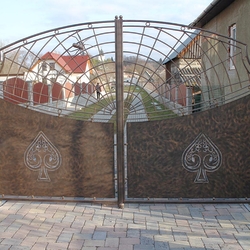 A wrought iron gate with a spider