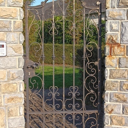 Portillon d'entre en fer forg compos de barreaux et volutes forg à chaud. Motif traditionnel.