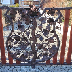 Toranlage – Wappen mit Weinrebe – handgeschmiedetes, mit Holz kombiniertes Tor an einem Einfamilienhaus Toranlage – Wappen mit Weinrebe – handgeschmiedetes, mit Holz kombiniertes Tor an einem Einfamilienhaus