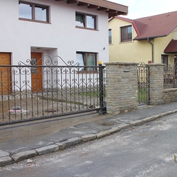Geschmiedetes Schiebetor und Pforte – schmiedeeiserner Zaun eines Einfamilienhauses Geschmiedetes Schiebetor und Pforte – schmiedeeiserner Zaun eines Einfamilienhauses