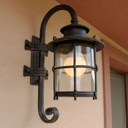 A wrought iron lamp with glass