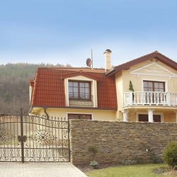 Celkový pohled na rodinný dům - kovaná brána, branka a mříže na oknech