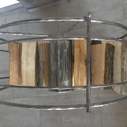 A forged wheel-shaped log holder – an original storage space for wood – view from above A forged wheel-shaped log holder – an original storage space for wood – view from above