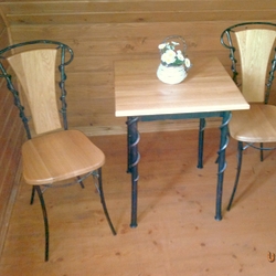 Kovaný stůl a židle jako součást nábytku v pokoji Šarišského penzionu