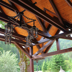 Suspension design en fer forgé dans une tonnelle de jardin d’un hôtel-restaurant (Slovaquie) – lustre à 4 ampoules