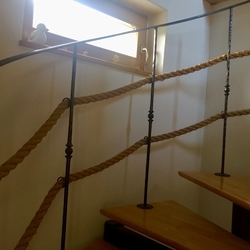 Kované zábradlí s lanem na interiérovém točitém schodišti