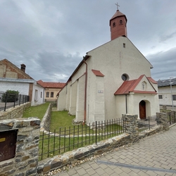 Oplocení kostela s ručně kovaným křížem v bráně v Ľubici