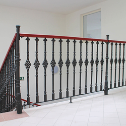 A historical forged railing - Cast iron railings with a wooden handrail in a historic house from the 16th century A historical forged railing - Cast iron railings with a wooden handrail in a historic house from the 16th century