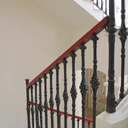 Hand wrought iron interior staircase railing with a wooden handrail