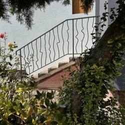 Modernes Schmiedeeisernes Geländer an der Treppe am Eingang des Einfamilienhauses - Außengeländer Modernes Schmiedeeisernes Geländer an der Treppe am Eingang des Einfamilienhauses - Außengeländer