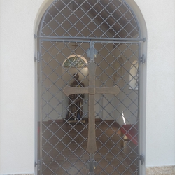 Kované mříže s křížem na kapli