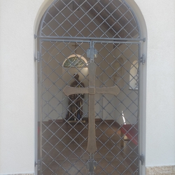 Geschmiedete Gitter mit einem Kreuz an einer Kapelle Geschmiedete Gitter mit einem Kreuz an einer Kapelle