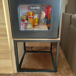 Einfacher Metalltisch unter dem Kühlschrank – moderne Hotelmöbel