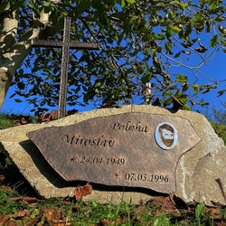 Kovaná tabule popisem a fotografií, kovaný kříž a růže na náhrobním kameni